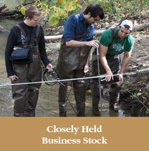 Students working on an outdoor project together. Closely Held Business Stock