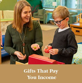 A woman working with a child. Gifts That Pay You Income